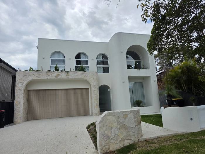 Completed rendered home exterior with arched windows, Sydney new home build